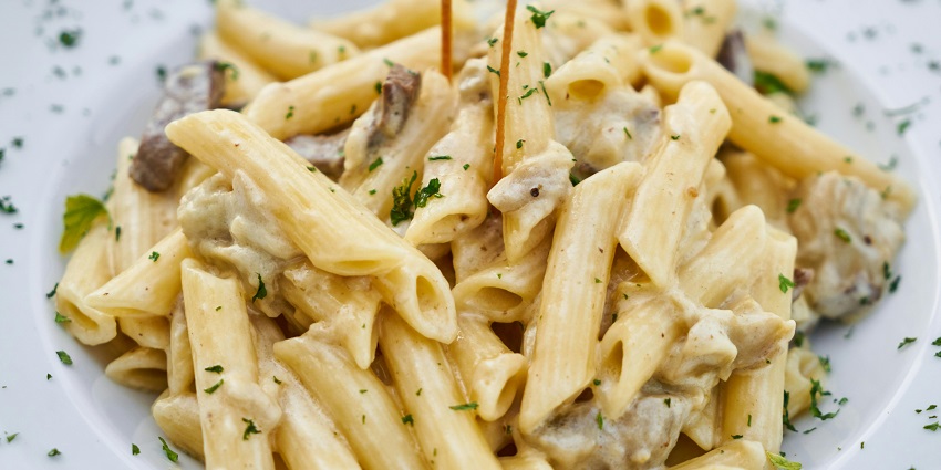 Creamy pasta served at Classic Grande’s Coffee Shop on a white plate.
