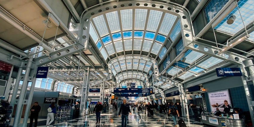 Interior view of Leh Airport terminal with passengers walking through the spacious area.