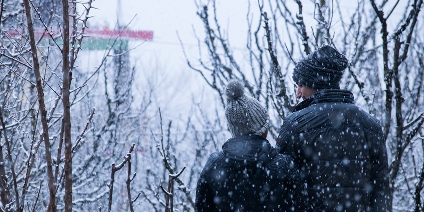 A couple walks hand in hand through fresh snowfall in the charming town of Manali.