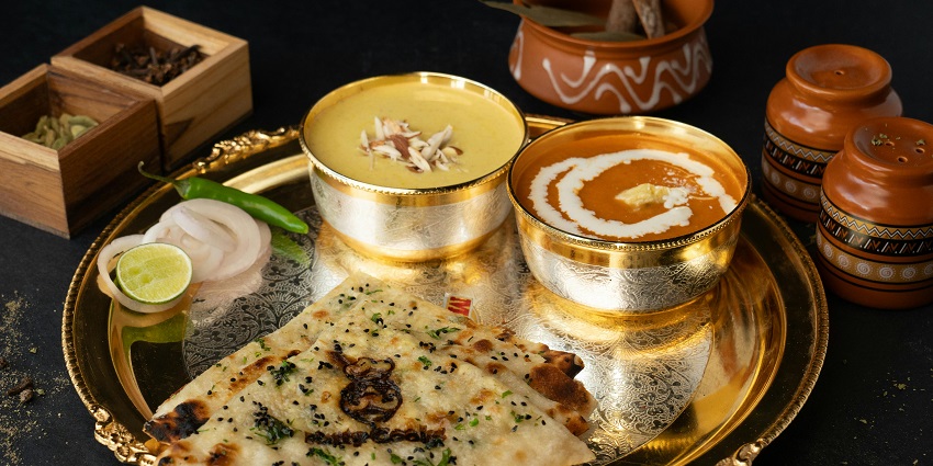 Indian thali with dal and naan served at D’ Backyard Tree Café Restro on a wooden table.