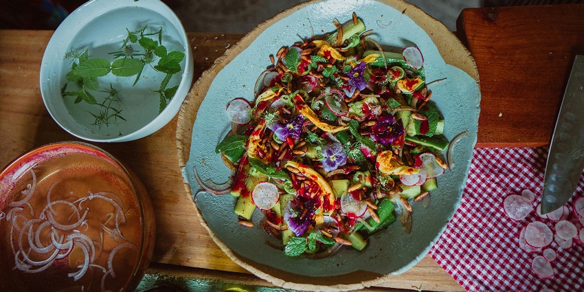 Colourful salad with radish, zucchini, herbs, and edible flowers, one of the charming restaurants in Tripura.