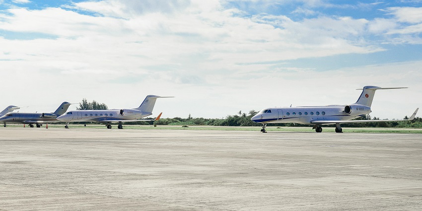 Multiple airplanes parked on the runway at an international airport.
