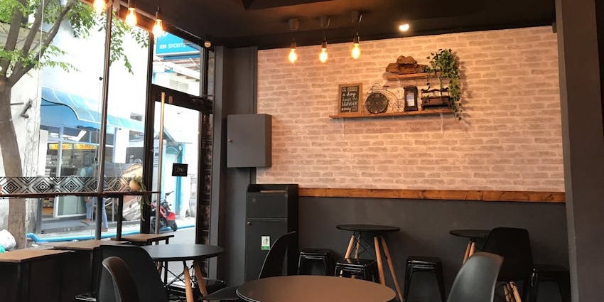 Gatty’s Café interior with black wooden tables, chairs, and hanging lights, one of the famous cafes in Darjeeling.