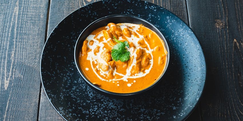 A pot with chicken curry garnished with coriander leaves served at Hot Spring Restaurant, one of the famous restaurants in Lachung.
