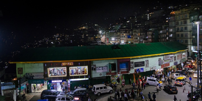 Gangtok city night view showing bright street lights, busy roads, and illuminated buildings.