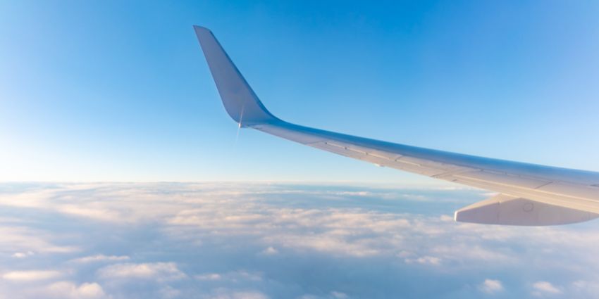 A view from the airplane window at a beautiful cloudy sky and the airplane wing.
