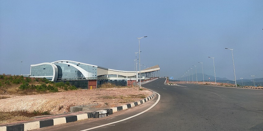 Modern exterior view of Kannur International Airport terminal with curved glass design.
