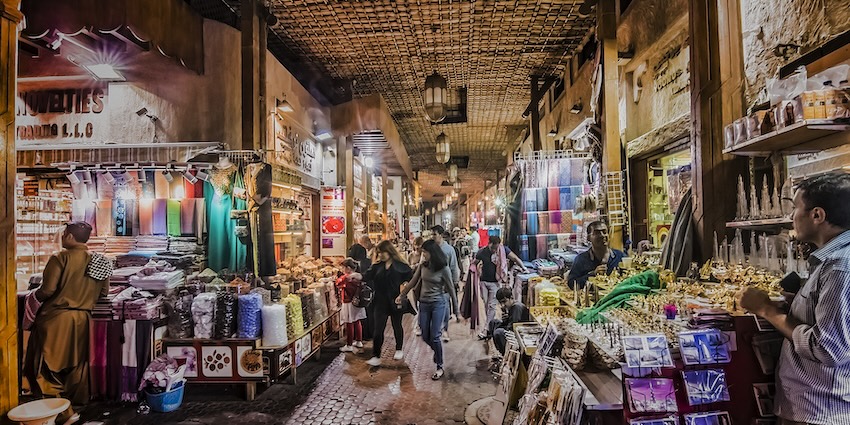 A view of the Karama market in Dubai, busy with people purchasing items at night.