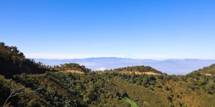 Beautiful green mountains and rolling hills under a bright blue sky in Manipur.