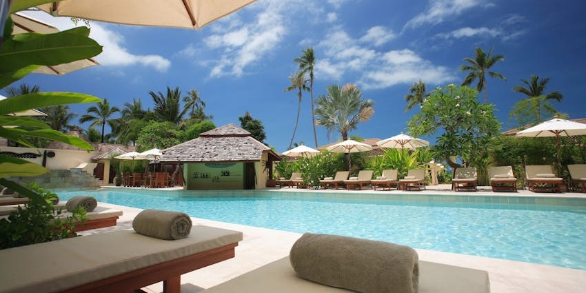 Interior of Mahabalipuram Beach Resort with swimming pool and lounge chairs.