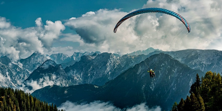 Paragliding coming in to land in the Solang Valley near Manali with mountains in the background.