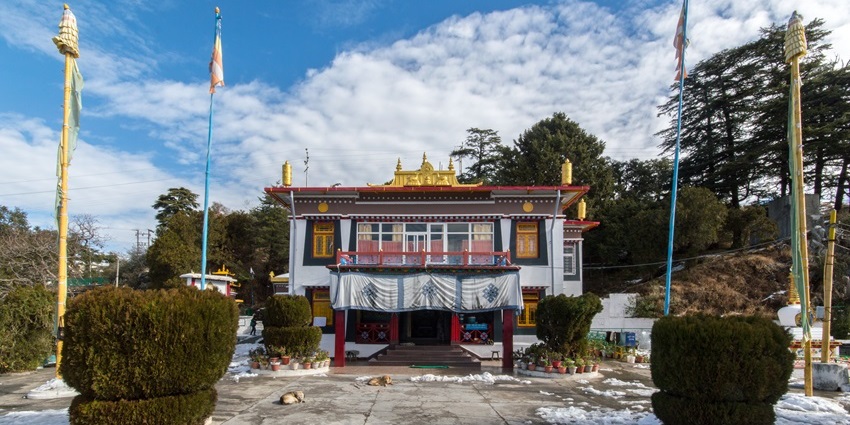 A captivating view of a monastery in Mussoorie surrounded by dusted snow and meadows.
