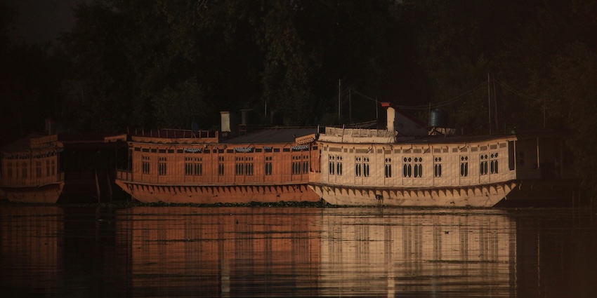Traditional houseboat on Nigeen Lake with its structure reflecting in the lake’s body