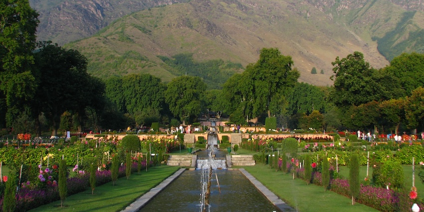 Nishat Bagh with water streaming down in the middle, surrounded by greenery and flowers