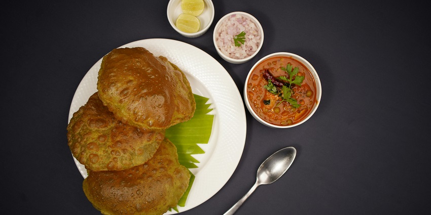 Chole bhature served on a plate at Rang De Basanti Dhaba.
