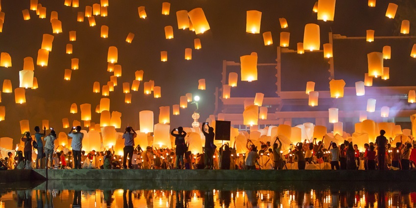 People releasing lanterns into the sky during the Yi Peng Lantern Festival in Chiang Mai.