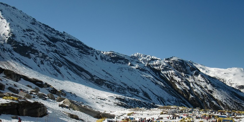 Vehicles and travellers surrounded by dense snowfall in Himachal Pradesh at Rohtang Pass.