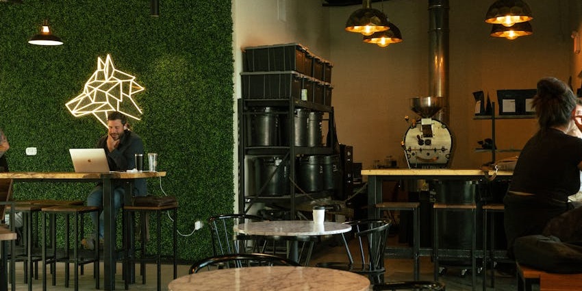 Modern café interior with marble tables, neon wolf wall art, one of the best cafes in Darjeeling.