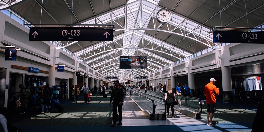 Interior view of a busy airport terminal with passengers and luggage.
