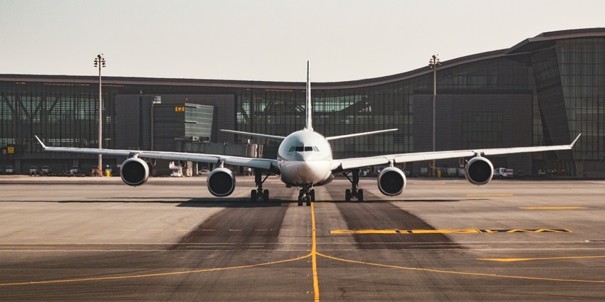 Airplane parked on the runway at Leh Airport with clear skies in the background.