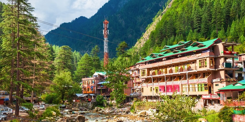 Traditional wooden houses along the main street in Kasol village in Himachal Pradesh during summer