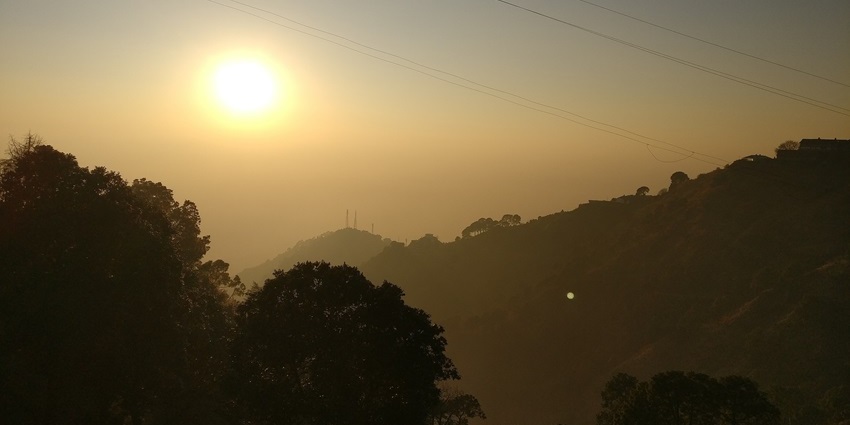 Golden sunset view from Sunset Point in Kasauli with silhouettes of trees and hills, showing snowfall in Kasauli.