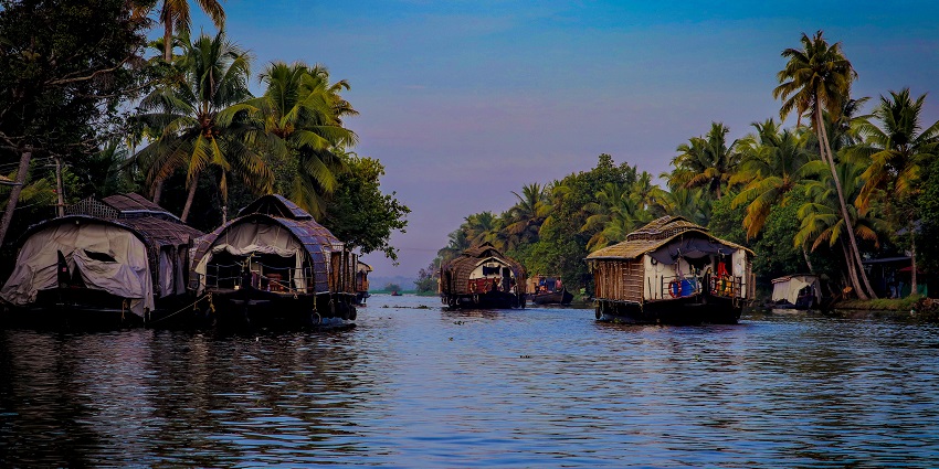Houses along the Tarkarli Backwaters with calm river and scenic surroundings.