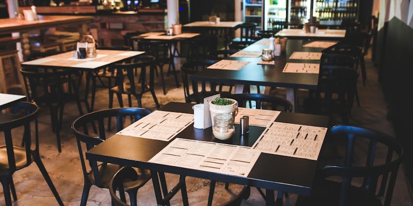 Taste of Lachung restaurant dining area with multiple tables and chairs, with a bar in the background.