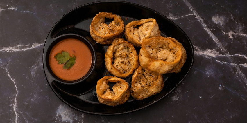 Delicious fried momos on a plate with a bowl of red chutney at The Bogong Kitchen, one of the restaurants in Pasighat.
