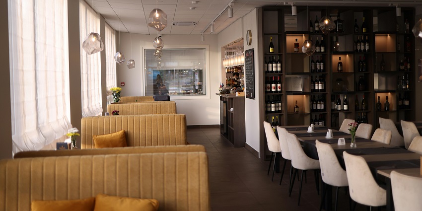 The Godfather restaurant with mustard sofas, cream chairs, and shelves, one of the restaurants in Silchar.
