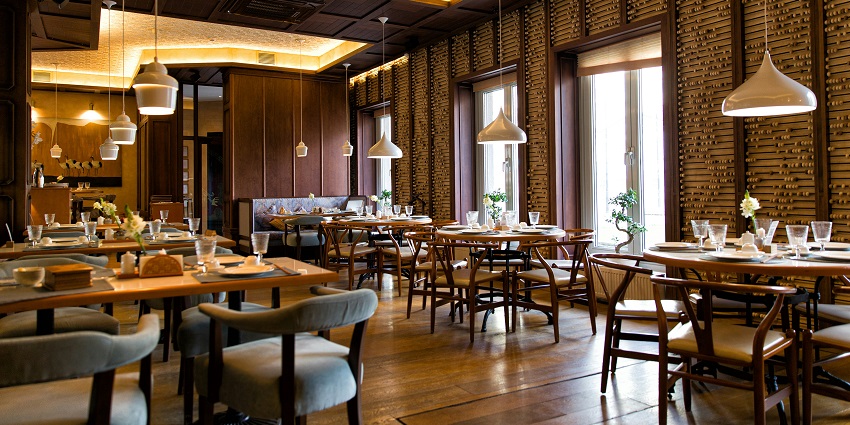 The Yellow Chilli interior with table, chairs, and hanging lights at one of the best restaurants in Guwahati for couples.
