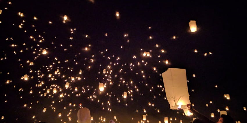 People are releasing glowing lanterns into the night sky during the festival.